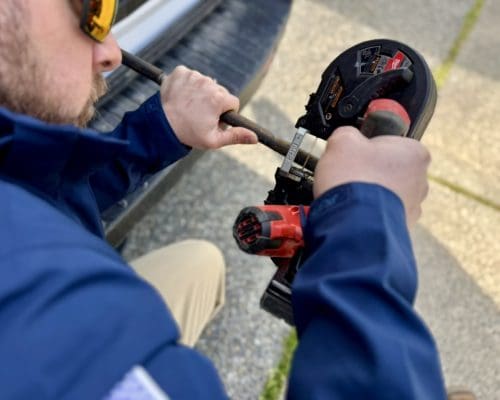 A plumber is busy on cutting tubes